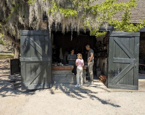 Girl and Father speaking to woman inside a barn