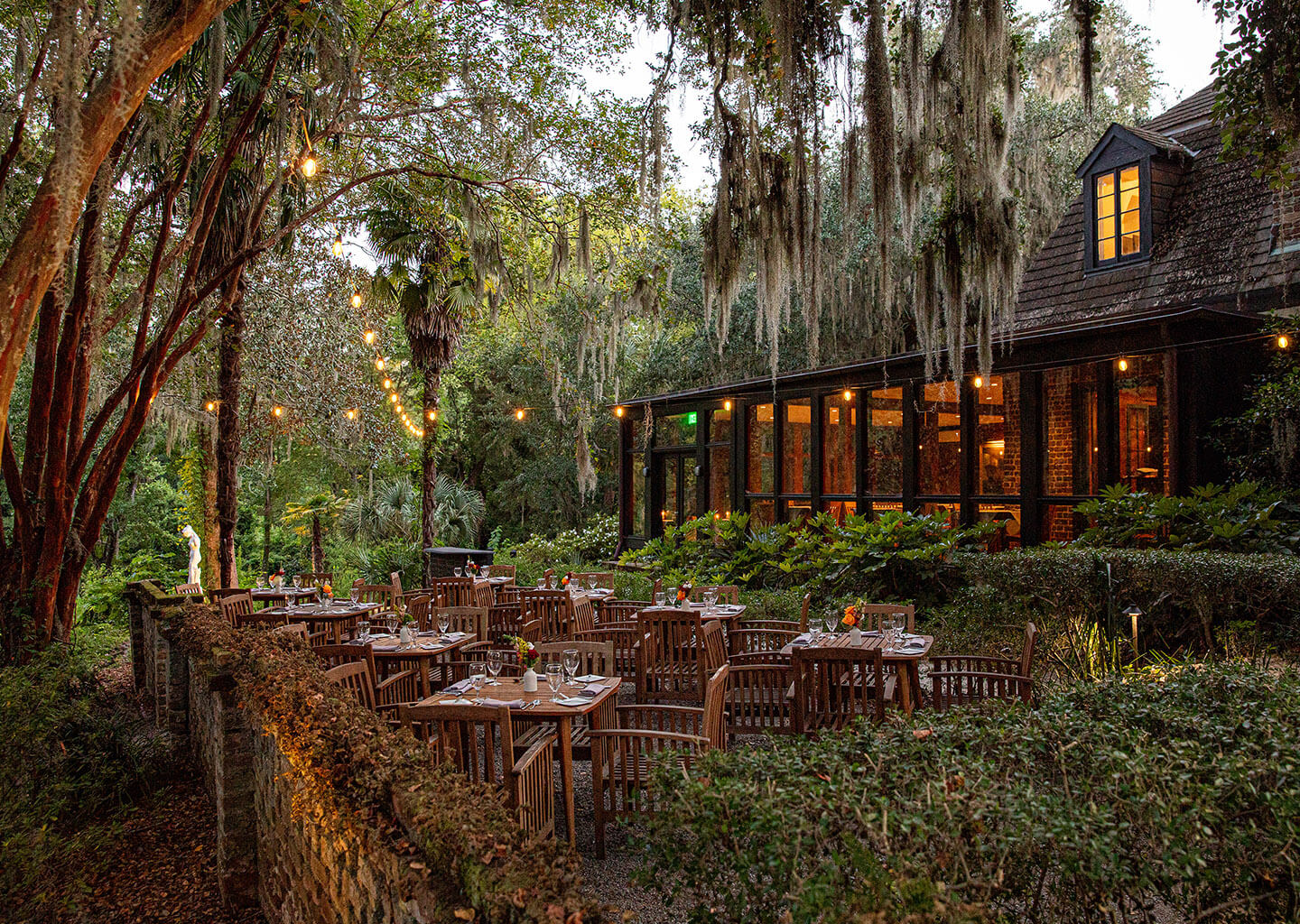 Modern cottage in the woods with warm-toned string lights and dining tables