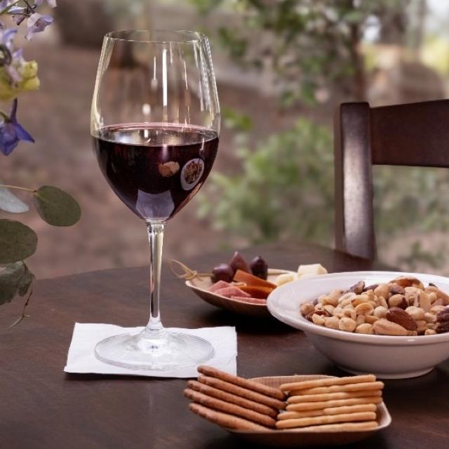 Wine next to nuts, cheese and crackers